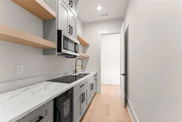 a kitchen with stainless steel appliances granite countertop white cabinets and a refrigerator