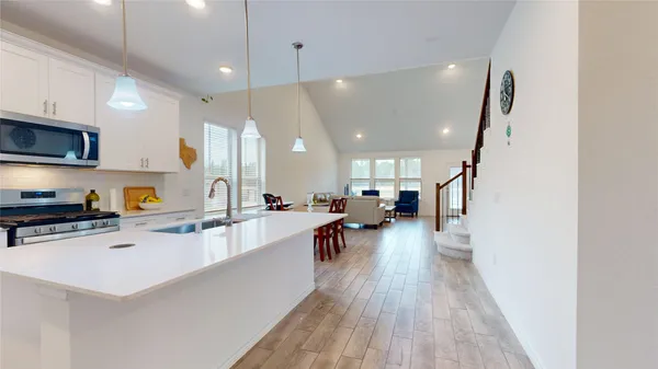 a kitchen with a sink a counter top space appliances and cabinets