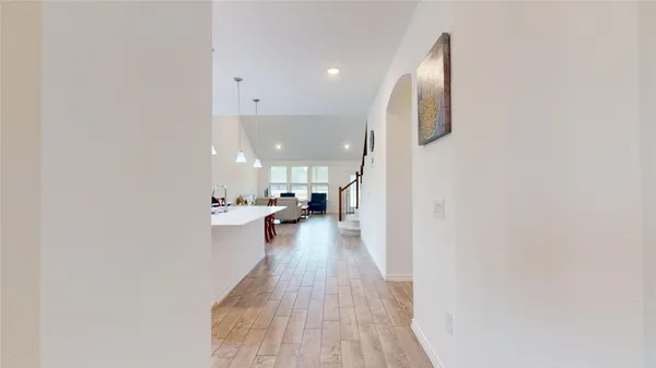 a view of a kitchen with kitchen island a sink wooden floor and a counter top space