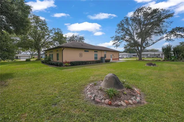 a white house with a big yard and large trees