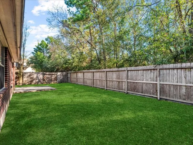 a view of yard with green space and wooden fence
