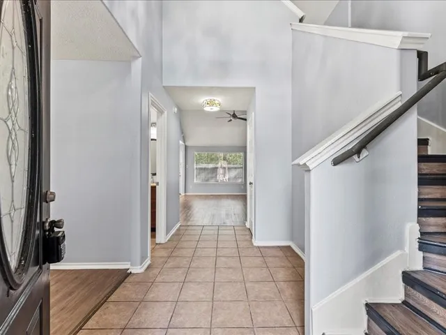 a view of a hallway with wooden floor and staircase