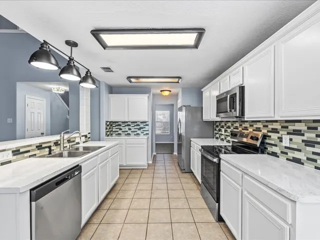 a kitchen with a sink stove and cabinets
