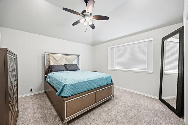 a bed sitting in a bedroom next to a window