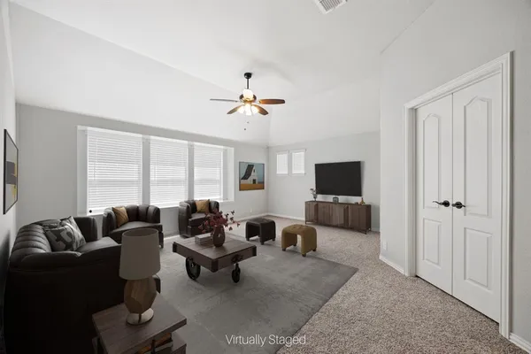 a living room with furniture ceiling fan and a flat screen tv