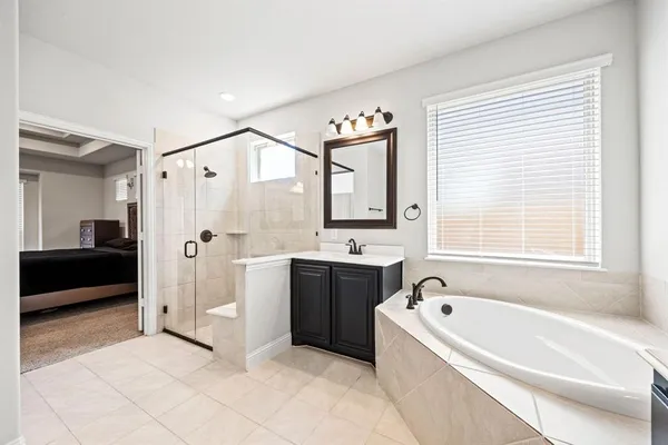 a bathroom with a bathtub a sink and a large mirror