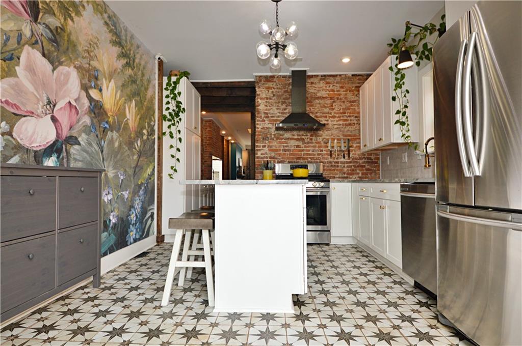 99 South 13th Street Pittsburgh, PA 15203 - Photo 13 of 50 a kitchen with stainless steel appliances granite countertop a refrigerator a sink dishwasher a oven with white cabinets and wooden floor