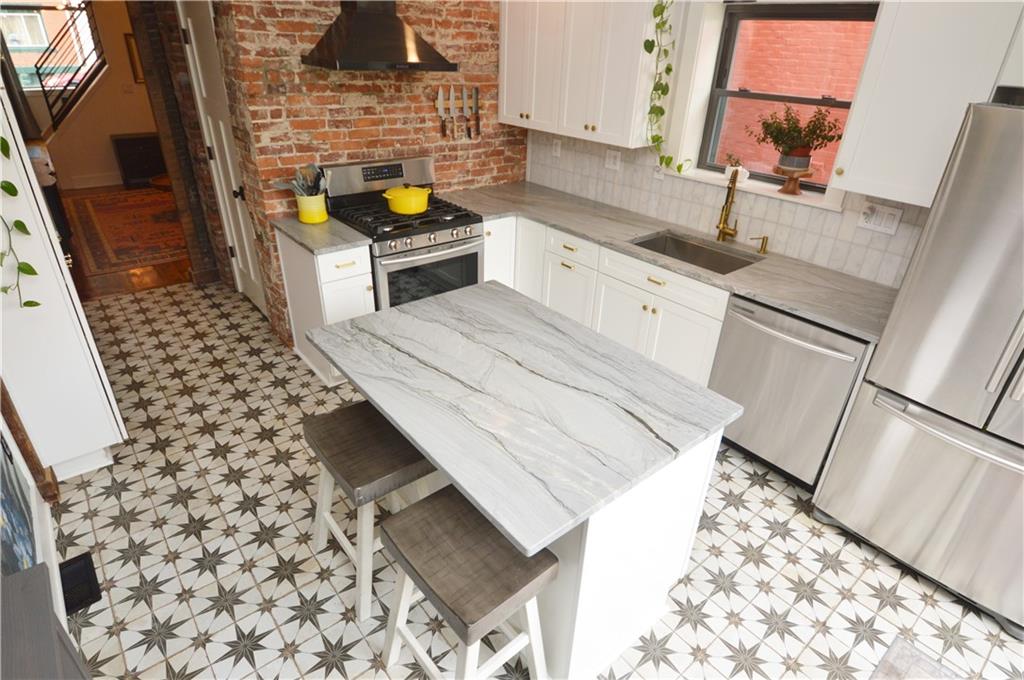 99 South 13th Street Pittsburgh, PA 15203 - Photo 16 of 50 a kitchen with sink cabinets and stove