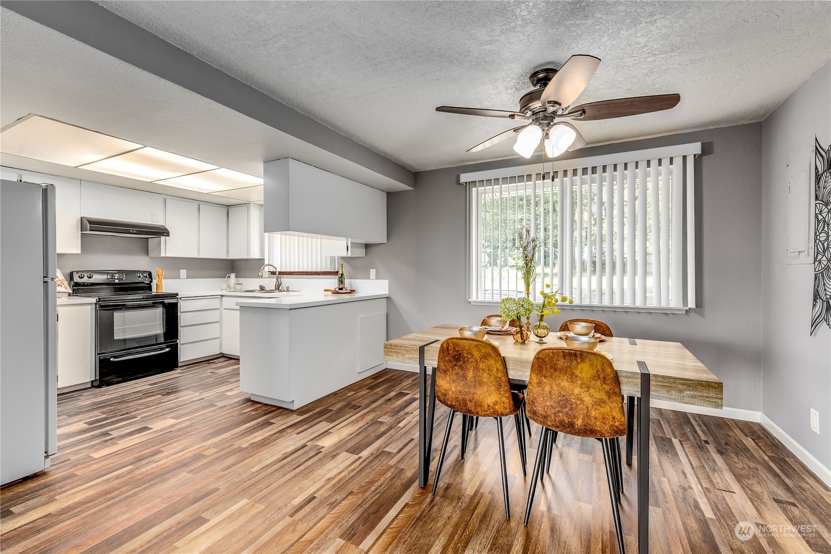 4751 Southeast Horstman Road Port Orchard, WA 98366 - Photo 12 of 40 a kitchen with stainless steel appliances wooden floor dining table and chairs