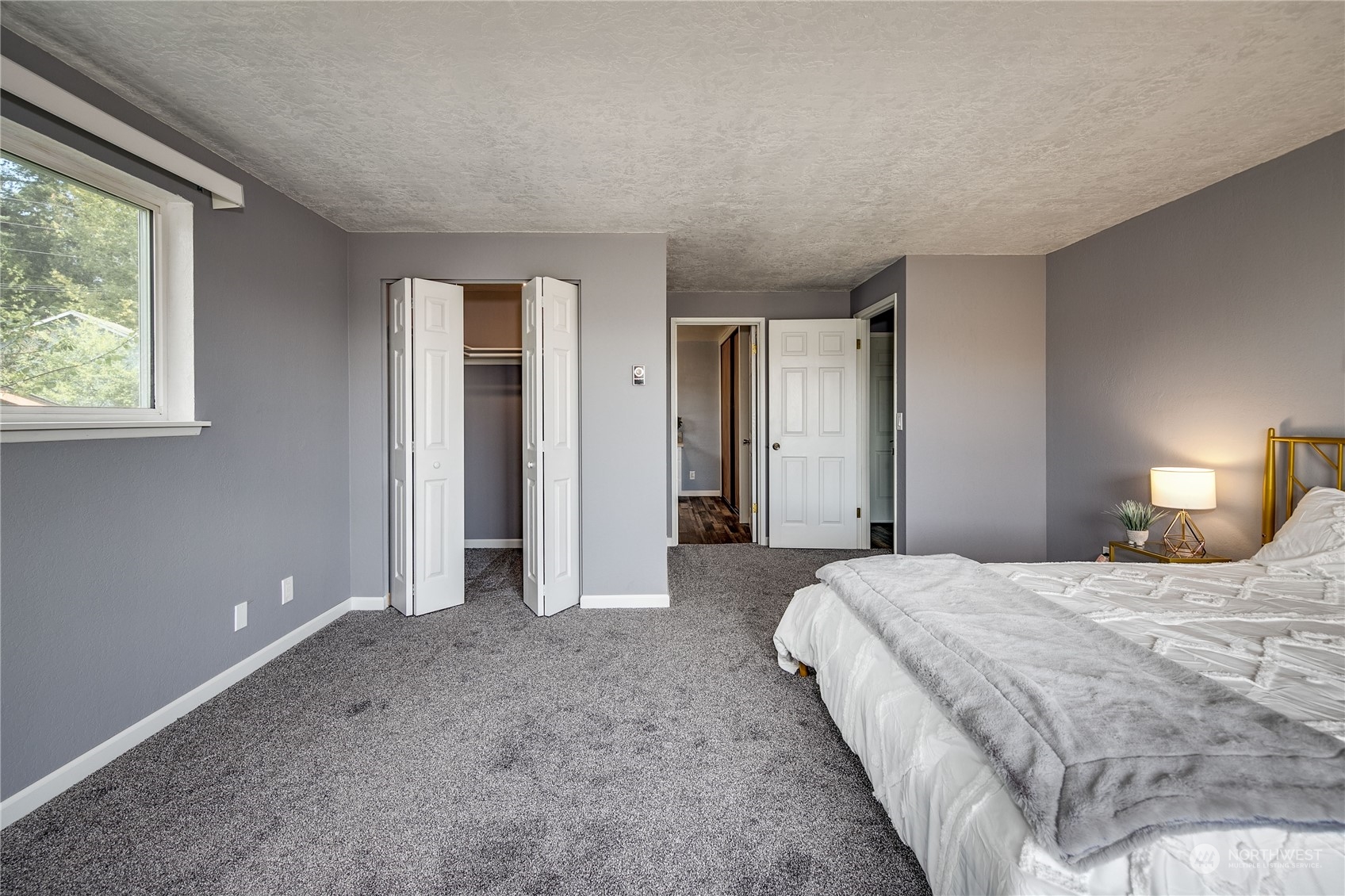 4751 Southeast Horstman Road Port Orchard, WA 98366 - Photo 18 of 40 a spacious bedroom with a bed and a lamp
