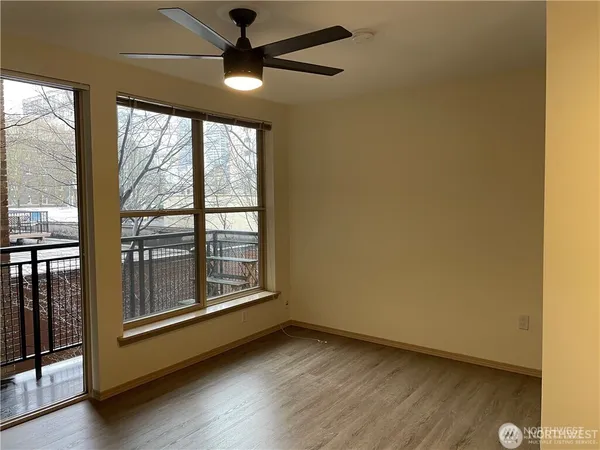 an empty room with wooden floor and windows