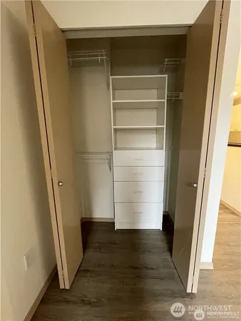a view of walk in closet with wooden floor