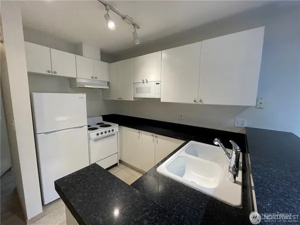 a kitchen with a sink appliances and cabinets