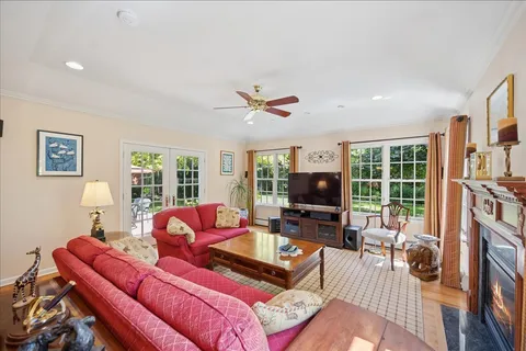 a living room with furniture a flat screen tv and a large window