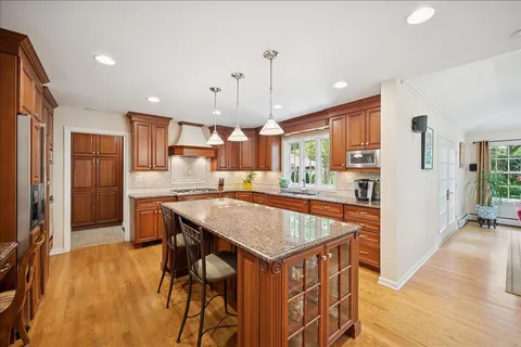 a kitchen with stainless steel appliances granite countertop table chairs sink and cabinets