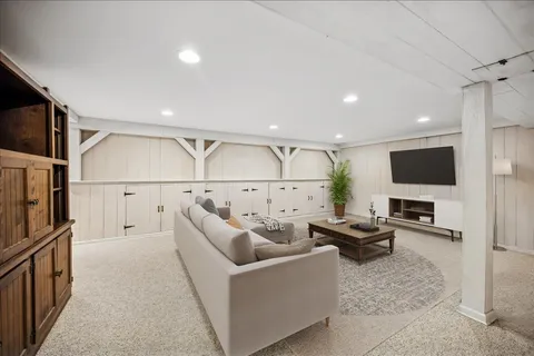 a living room with couches a flat screen tv and kitchen view