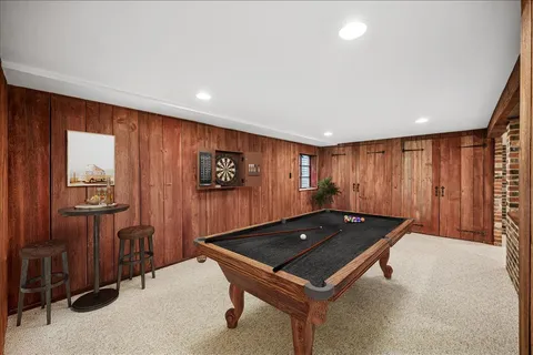 a room with furniture pool table and chandelier
