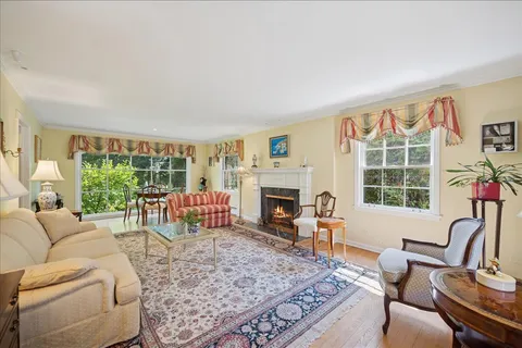a living room with furniture large window and fireplace