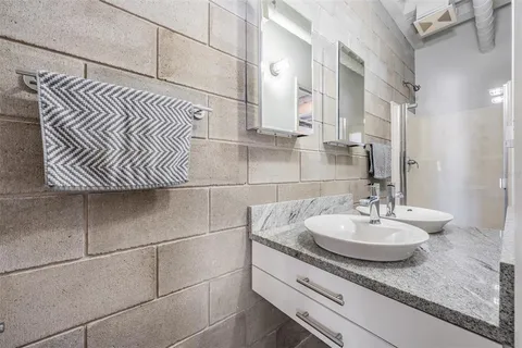 a bathroom with a granite countertop shower and a sink
