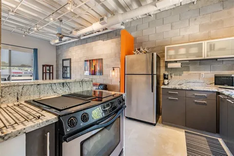 a kitchen with stainless steel appliances granite countertop a sink stove and refrigerator