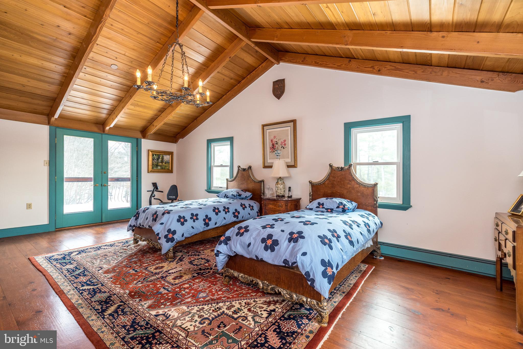 23 Lily Valley Road Erwinna, PA 18920 - Photo 22 of 81 a bedroom with two beds and a chandelier