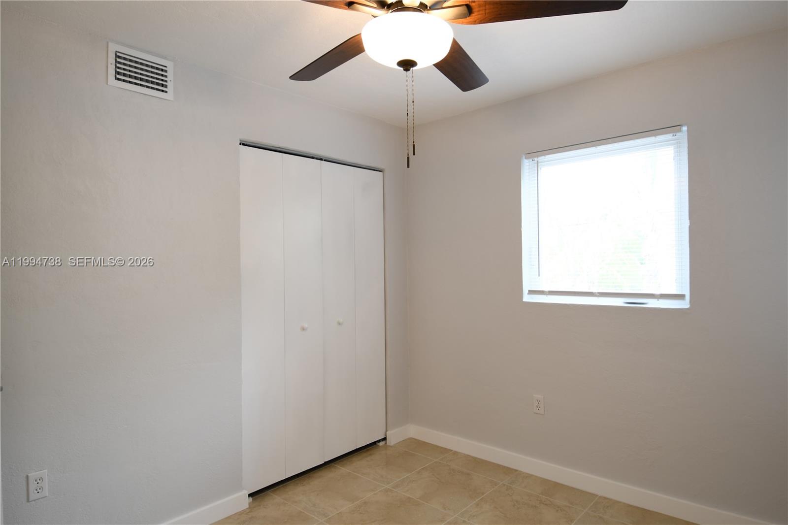 1398 Northwest 61st Street, Unit 10 Miami, FL 33142 - Photo 4 of 8 a view of an empty room with a window