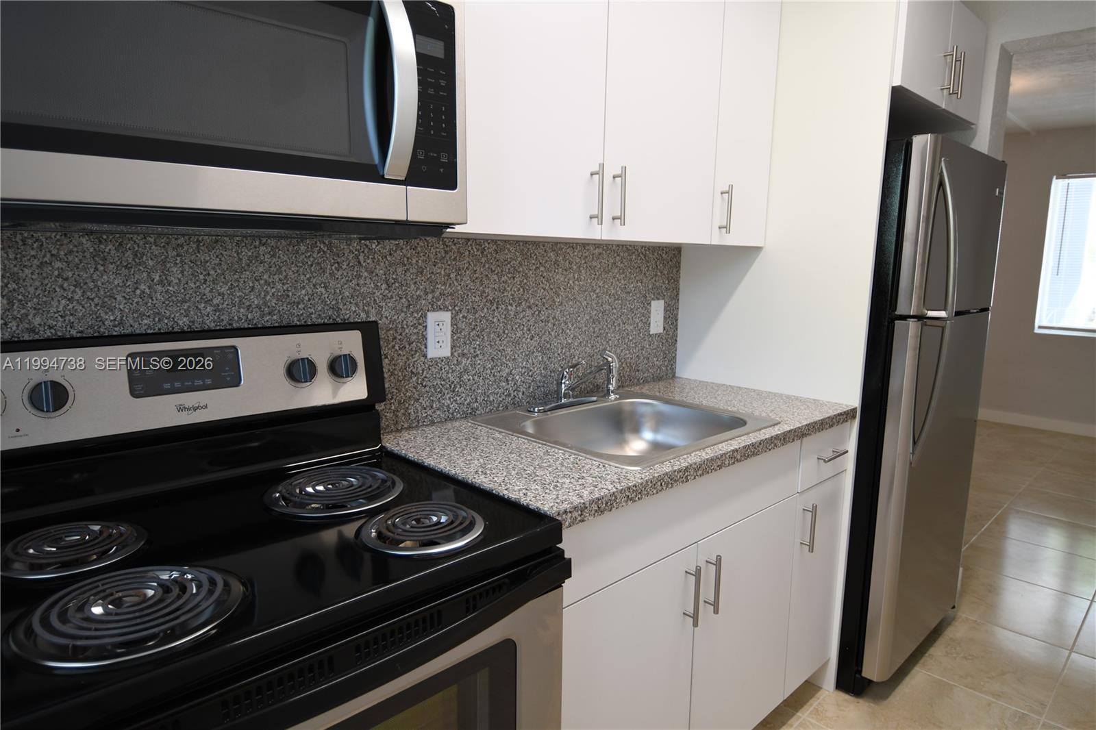 1398 Northwest 61st Street, Unit 10 Miami, FL 33142 - Photo 7 of 8 a kitchen with a stove and a refrigerator
