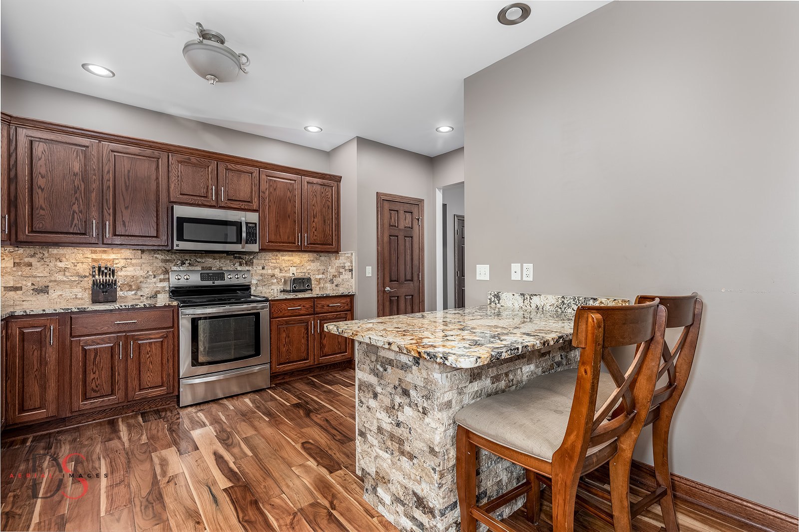 2834 East 2525th Road Marseilles, IL 61341 - Photo 16 of 31 a kitchen with stainless steel appliances granite countertop a stove top oven a sink dishwasher a dining table and chairs with wooden floor