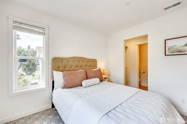 a bedroom with a bed and a potted plant