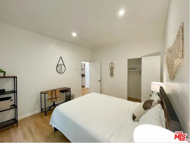 a bedroom with a bed and wooden floor