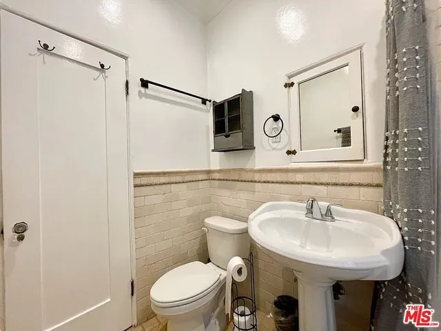 a bathroom with a sink a toilet and a mirror