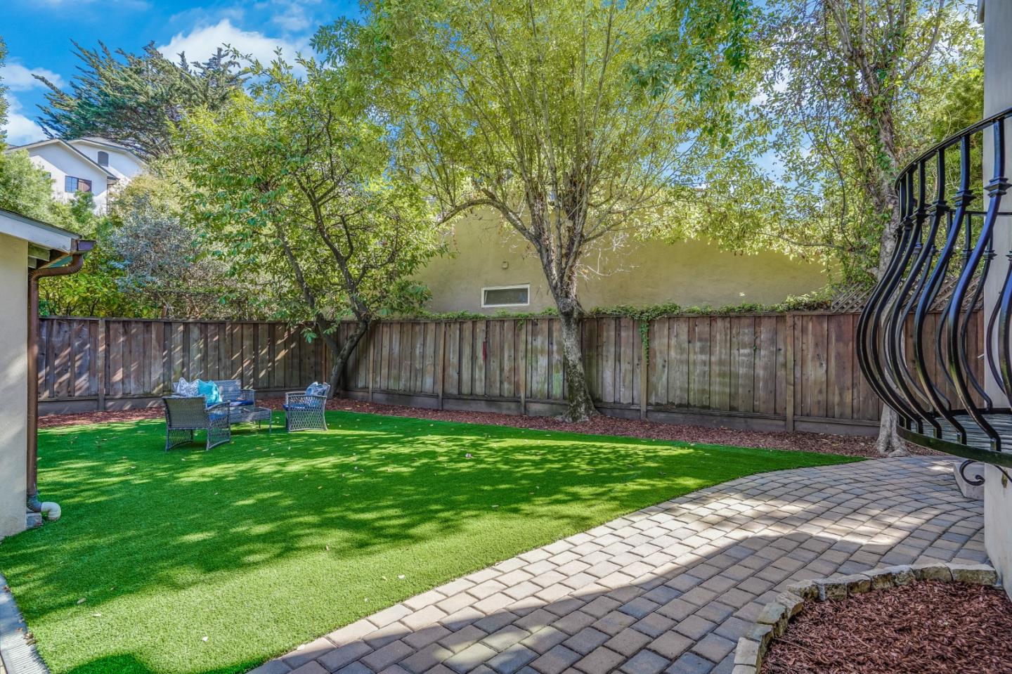 720 Edgewood Road San Mateo, CA 94402 - Photo 43 of 56 a view of a backyard with table and chairs and wooden fence