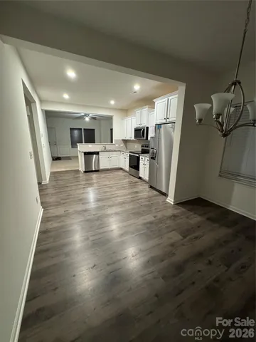 a view of a kitchen with furniture and wooden floor