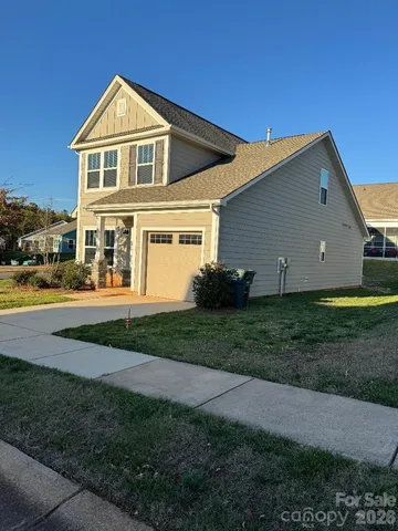 a front view of a house with a yard and trees