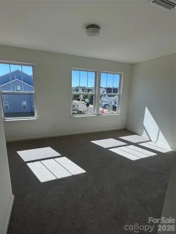 a view of an empty room and chandelier