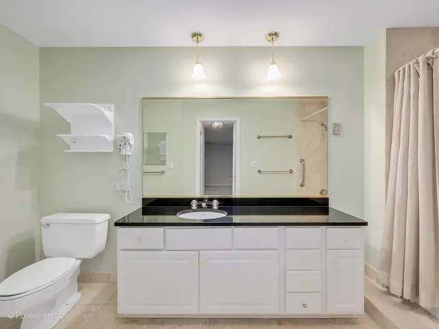 a bathroom with a granite countertop sink mirror and a bathtub