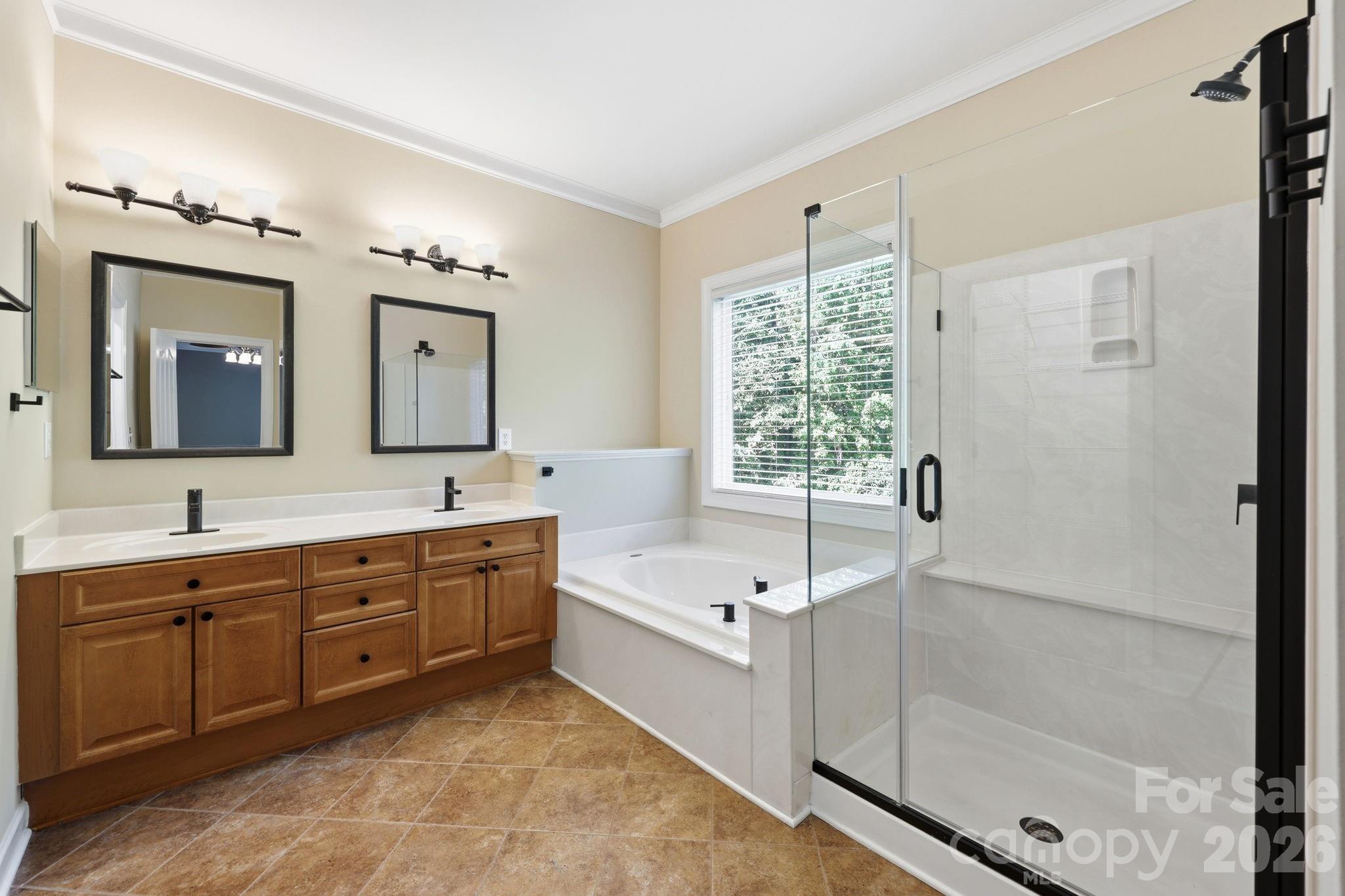 3308 Grandeur Road Charlotte, NC 28269 - Photo 20 of 45 a spacious bathroom with a double vanity sink a large mirror and a bathtub