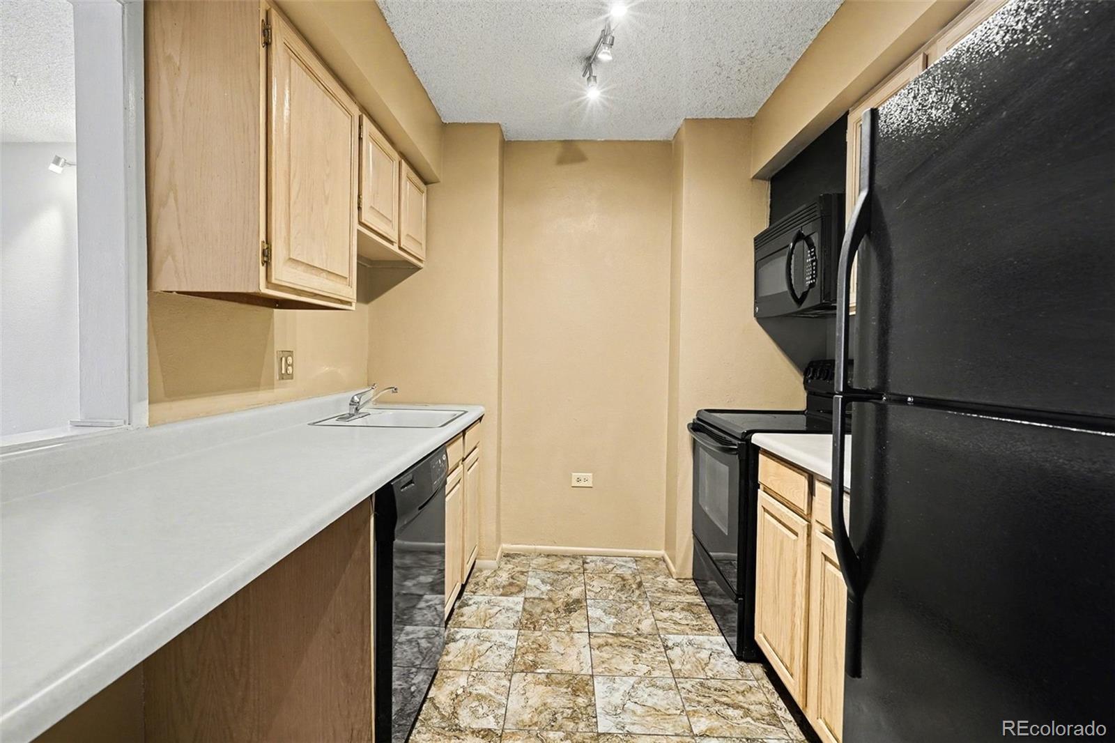 1020 15th Street, Unit 13N Denver, CO 80202 - Photo 2 of 12 a kitchen with a sink stove and refrigerator