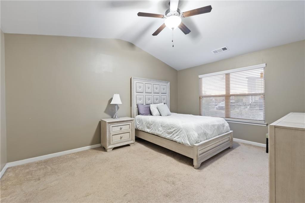 5715 Radford Loop Fairburn, GA 30213 - Photo 18 of 26 a spacious bedroom with a bed and a chandelier