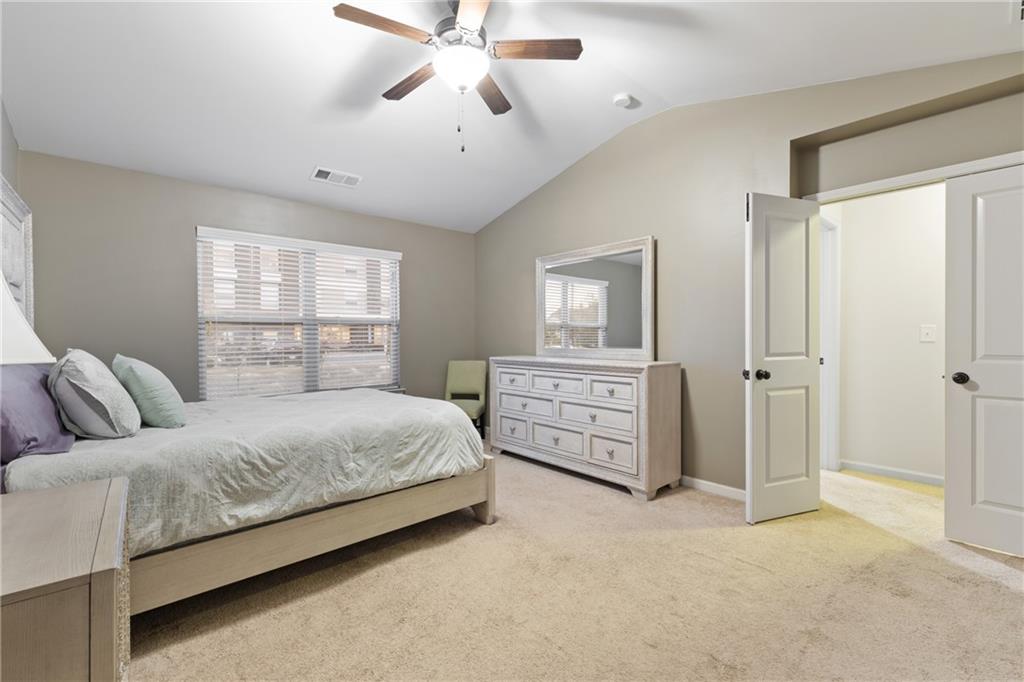 5715 Radford Loop Fairburn, GA 30213 - Photo 19 of 26 a bedroom with a large bed and a chandelier