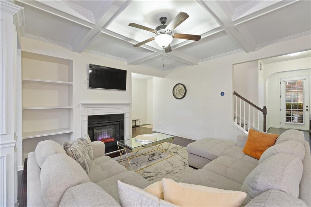 5715 Radford Loop Fairburn, GA 30213 - Photo 5 of 26 a living room with furniture a fireplace and a flat screen tv