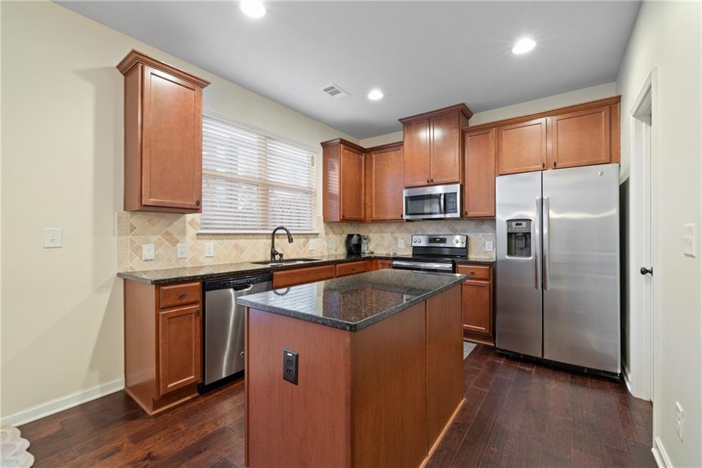 5715 Radford Loop Fairburn, GA 30213 - Photo 10 of 26 a kitchen with stainless steel appliances granite countertop a refrigerator a sink dishwasher a stove and a microwave oven on granite countertops