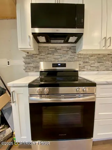 a stove top oven sitting inside of a kitchen