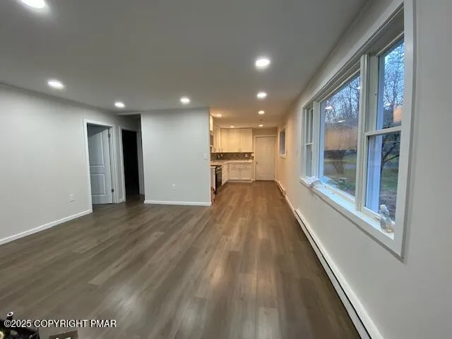 a view of a big room with wooden floor and windows