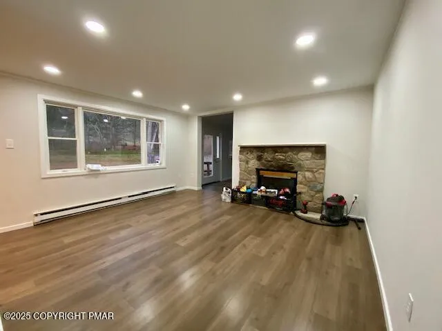 a view of empty room with wooden floor and fireplace
