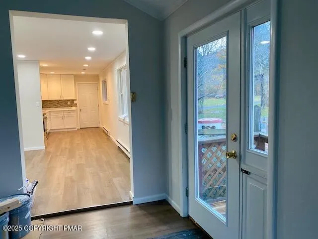 a view of a hallway with wooden floor and windows