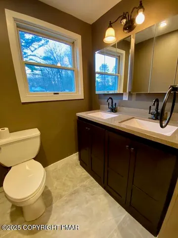 a bathroom with a toilet sink and mirror