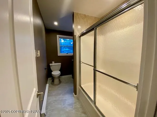 a bathroom with a toilet and a shower