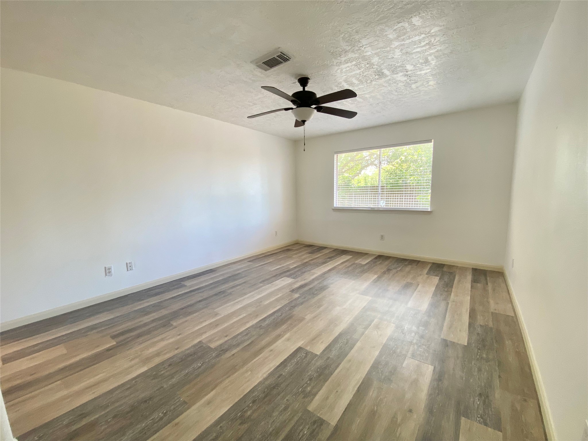 4203 Breckenridge Drive Houston, TX 77066 - Photo 20 of 43 an empty room with windows and ceiling fan view