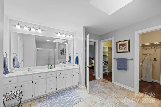 a bathroom with a double vanity sink mirror and shower